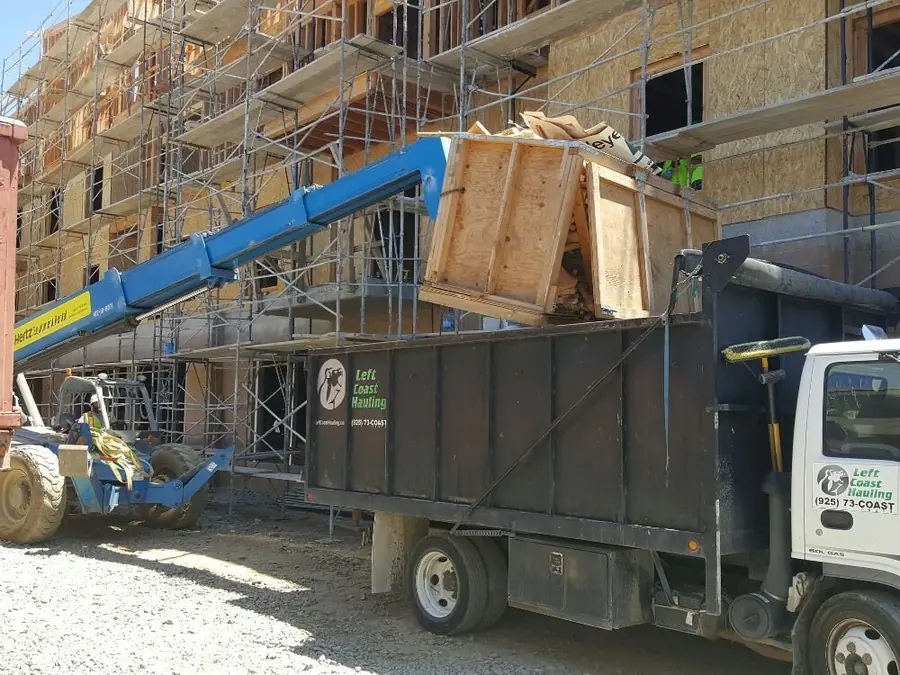 Debris lowered into a Left Coast Hauling truck at a multi-story build