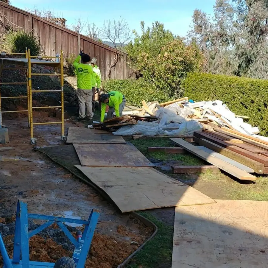Crew sorting lumber and plywood scraps at a build site